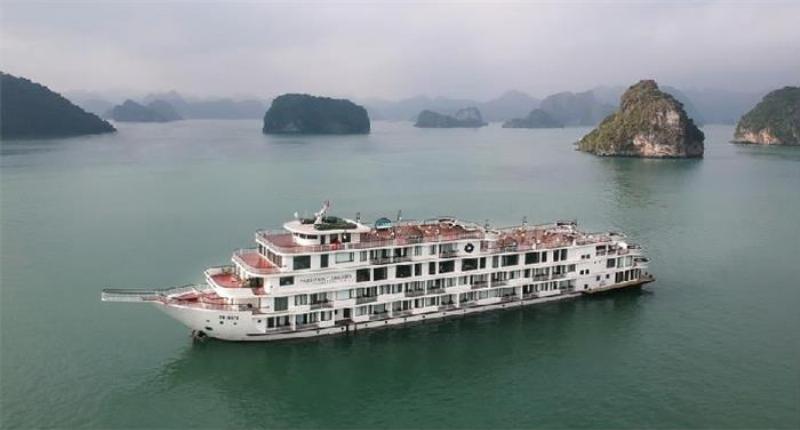 Hai du khach dang vui ve chup anh check in tren san tau voi khung canh vinh Ha Long dang sau.